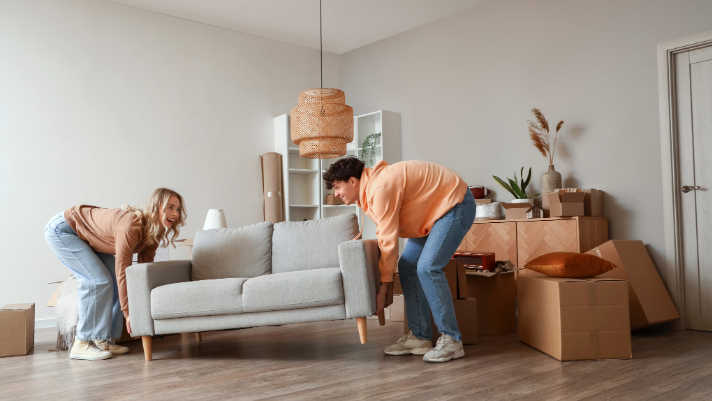 Photo of a Woman and Man Moving a Couch