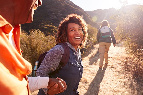 man and woman on a trail in the sunshine