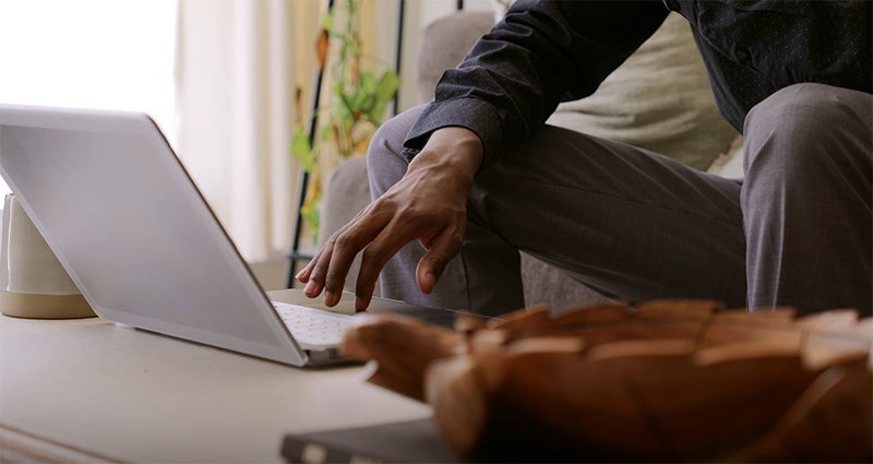 hombre con laptop sentado en el sofá