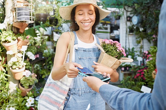 Woman in flower shop using tap to pay