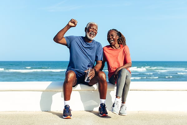 happy, older couple working out on the beach