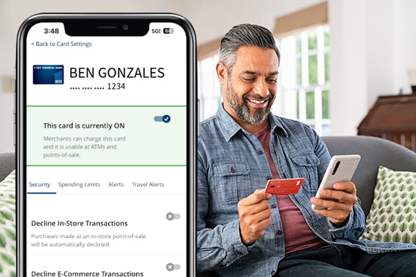man holding debit card and phone