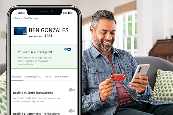 hombre sosteniendo tarjeta de débito y teléfono