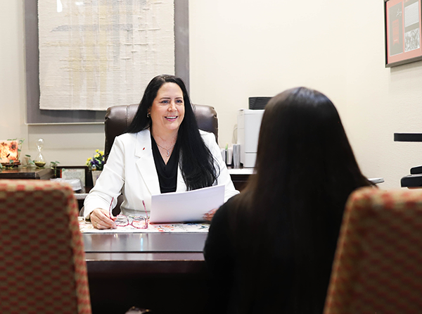 Woman at her desk talking with another employee