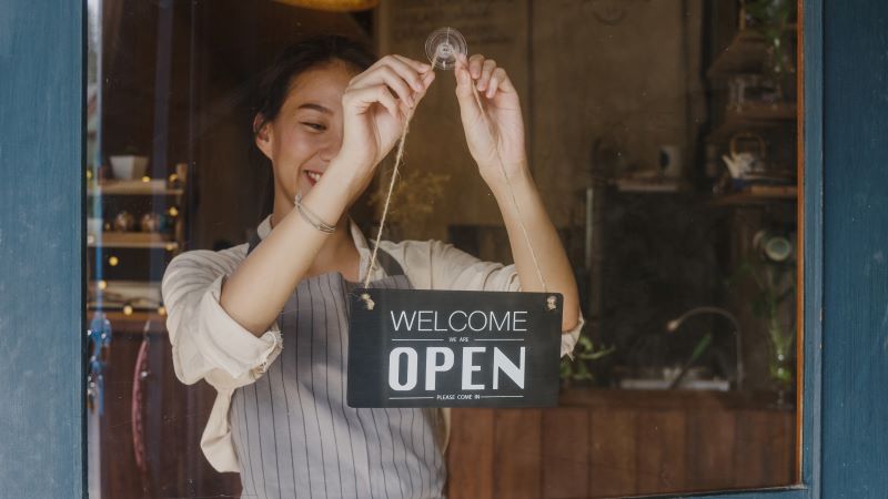 Foto de mujer empresaria abriendo su tienda