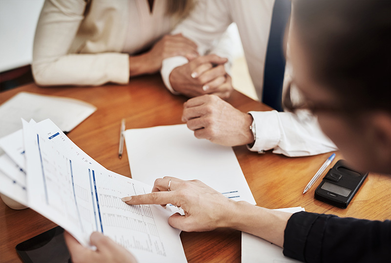 Image of a couple and an advisor looking at documents