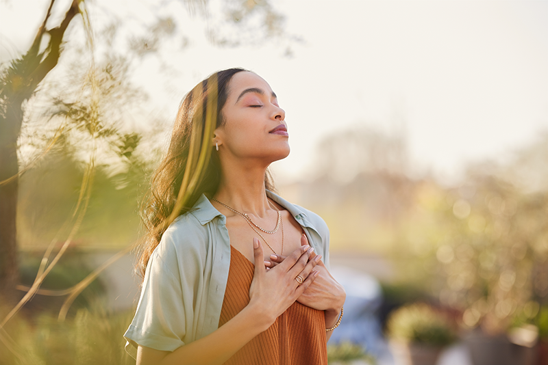 Mujer respirando profundamente en la naturaleza